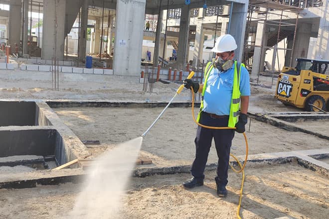 Technician spray-treating the ground on an active Dubai construction site
